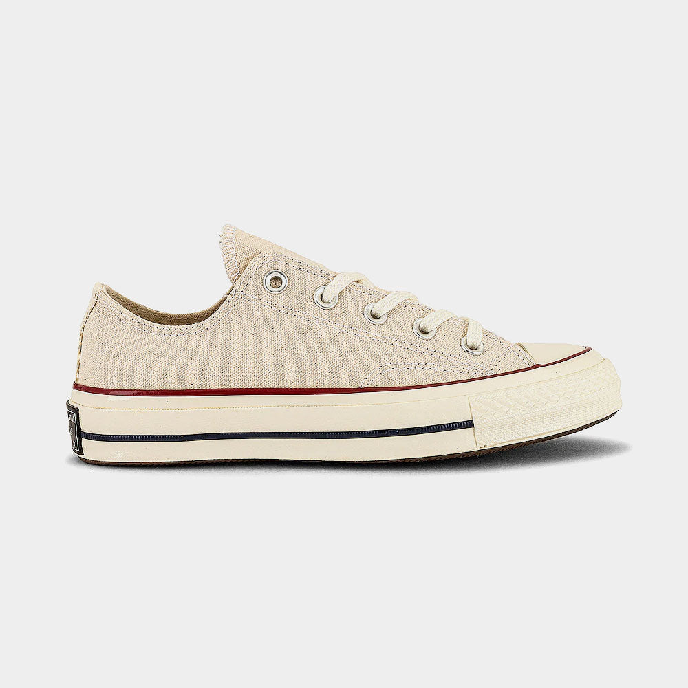 Beige sneaker with red and blue accents on a light gray background